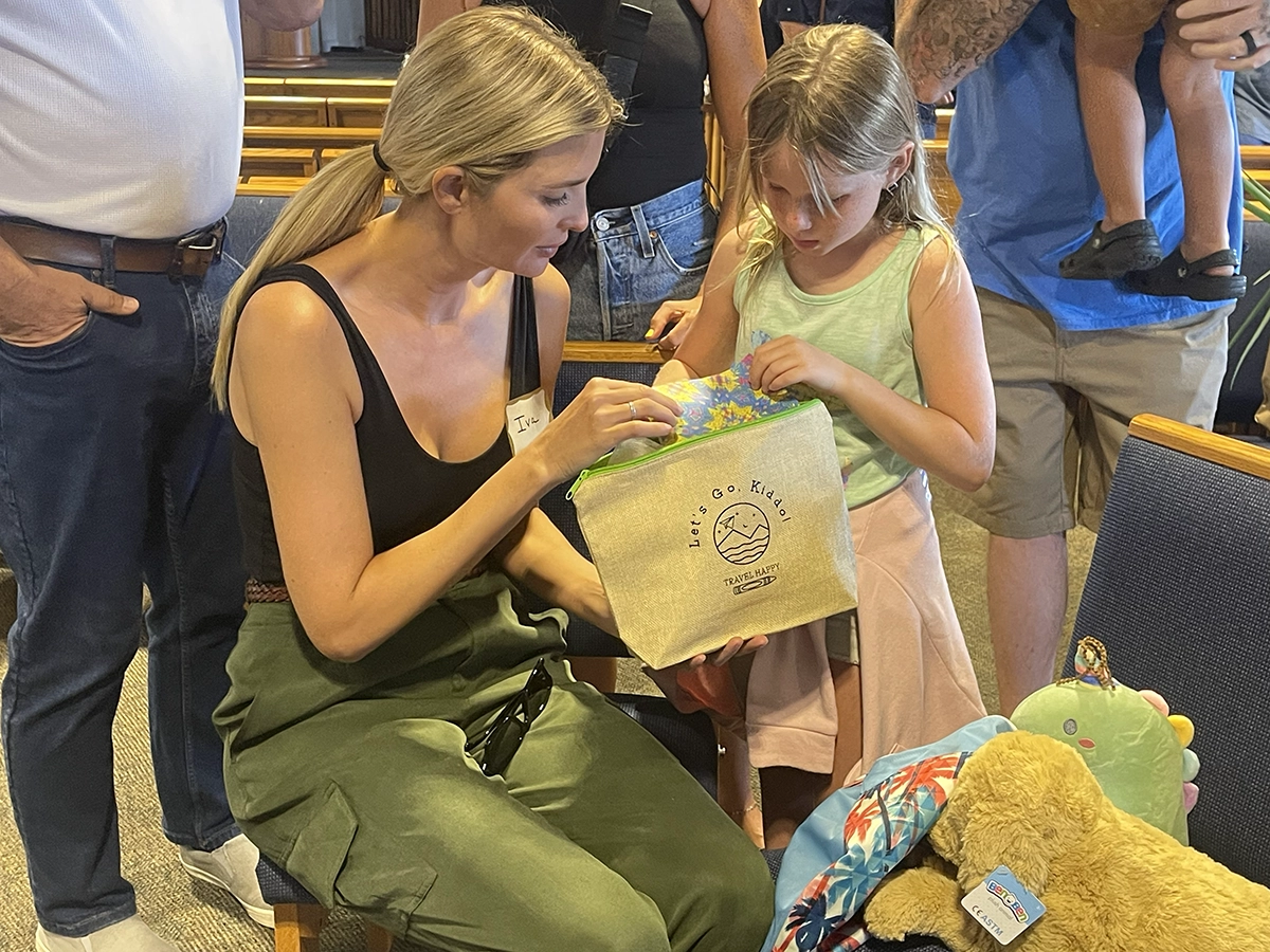 Ivanka Trump and a young girl looking inside a bag.